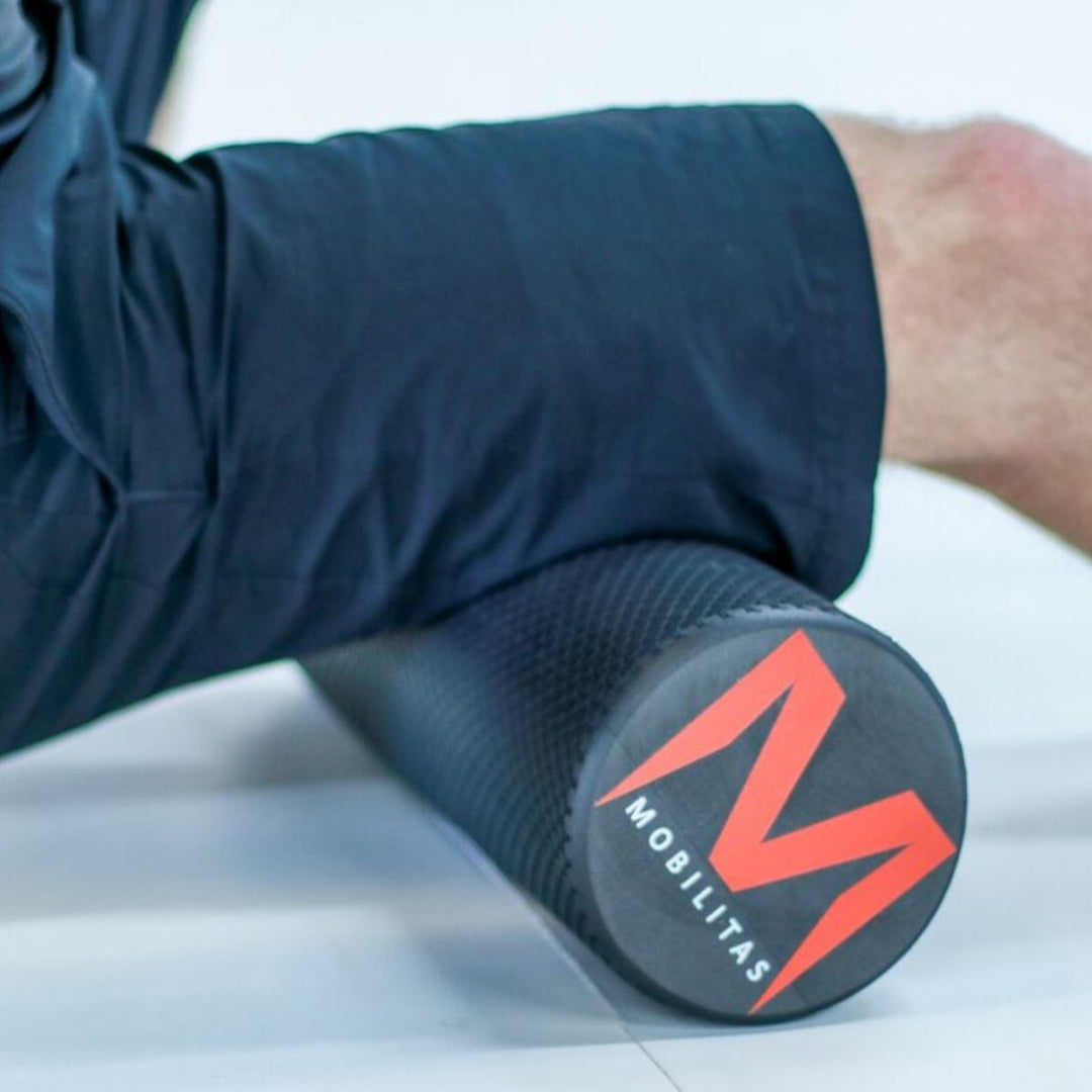 foam roller - man rolling hamstring sore muscles